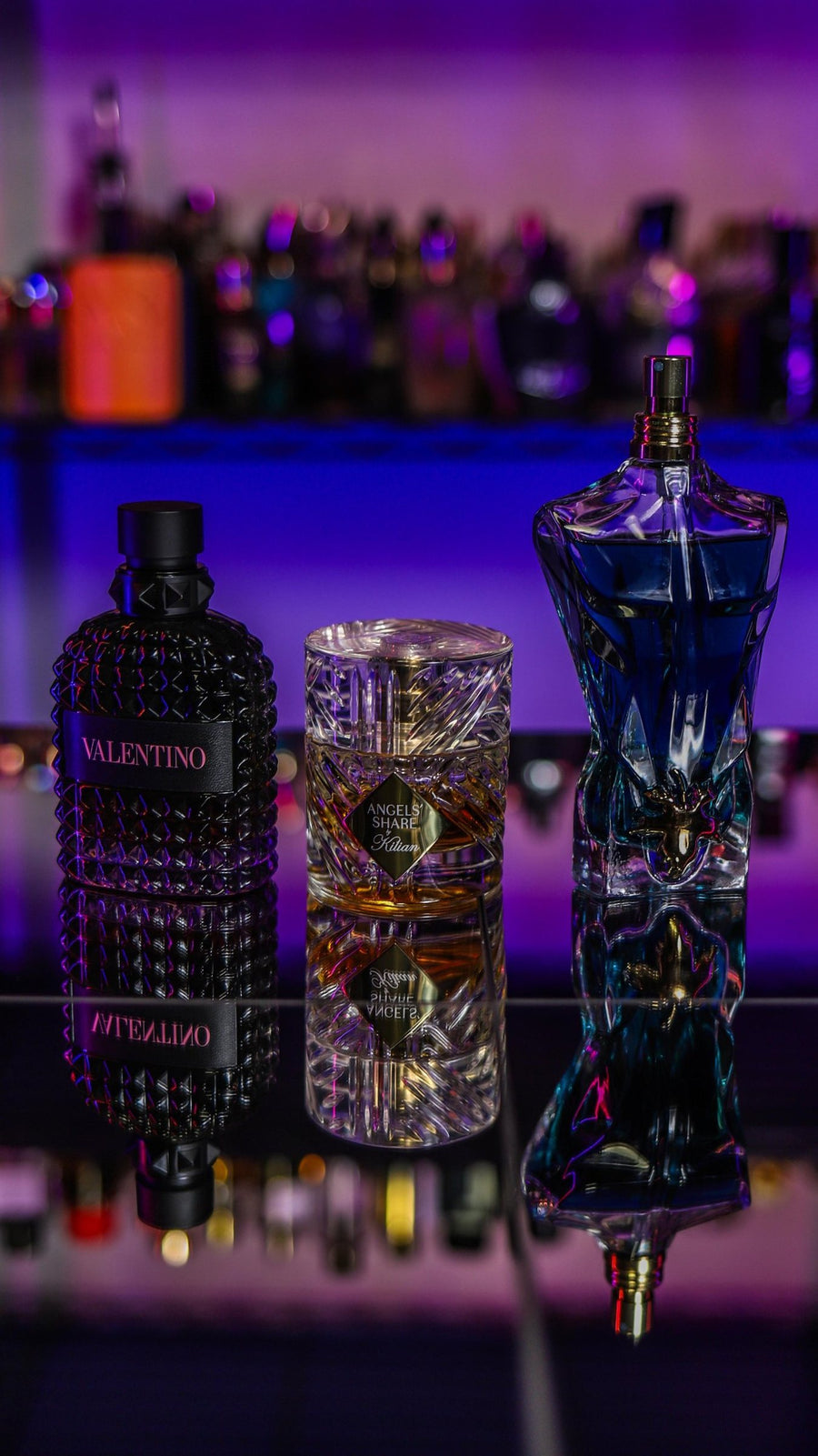 Perfumes de Valentino, Kilian, Creed y Amouage reflejados sobre la barra